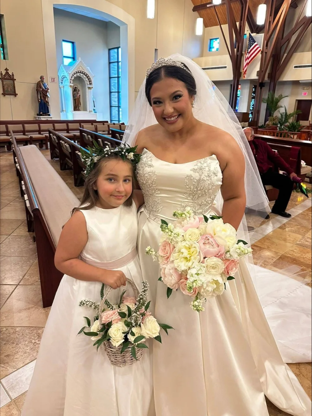 Bride and flower girl carrying coordinated floral pieces
